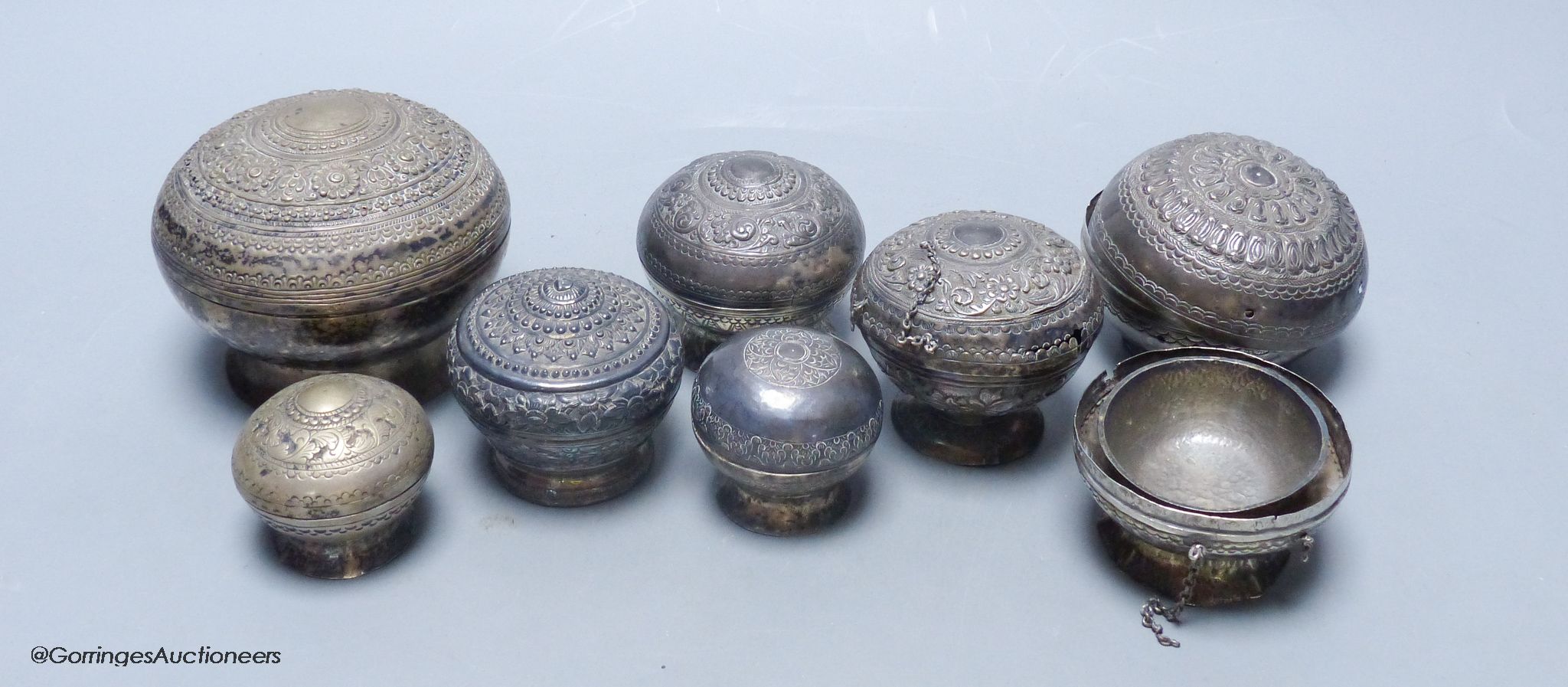 A collection of Malay Straits white metal circular betel nut boxes ('Chimbul'), Diameter 5cm to 10cm